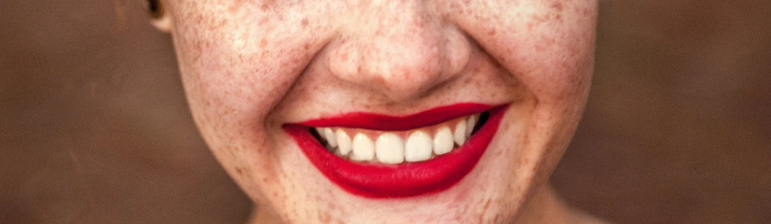 Close Up of a Beautiful Smiling Woman Wearing Red Lipstick Cosmetic Dentistry