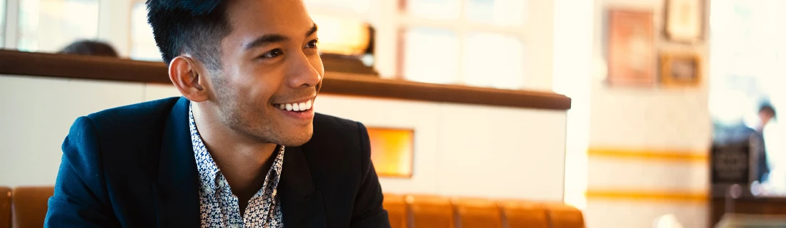 Man in a Nice Suit Sitting in a Cafe Smiling Across the Table Showing off Bridges